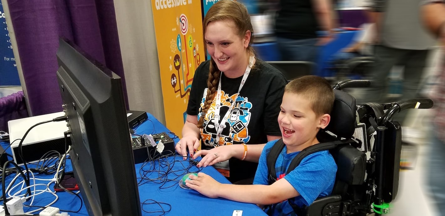 Peer Counselor playing video games with a young boy in a wheel chair