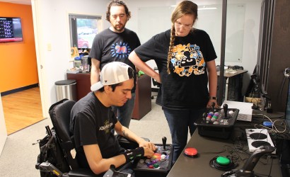 Mark Barlet and Jessie Hall watching a player use an Axis controller.