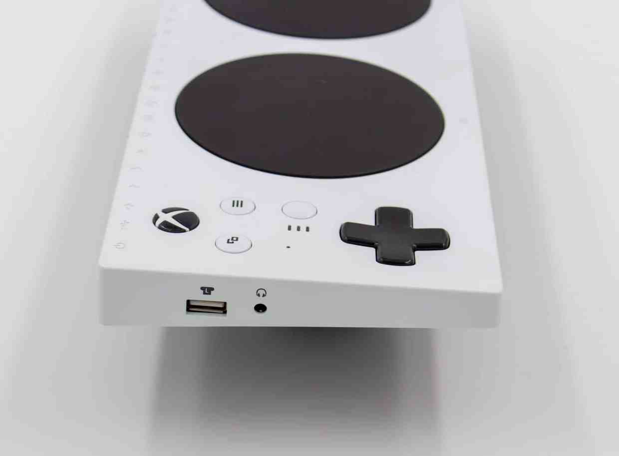 The side of an Xbox Adaptive Controller. There is a USB port and an audio port with icons above them.