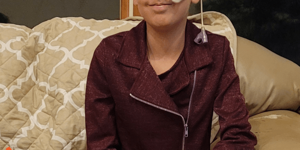 A photo of Bella, she has short brown hair and she is smiling