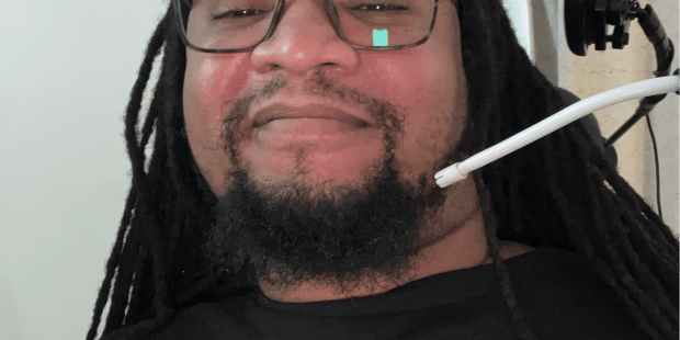 A photo of Brandon, a young man, he has black hair and a beard and he is wearing glasses