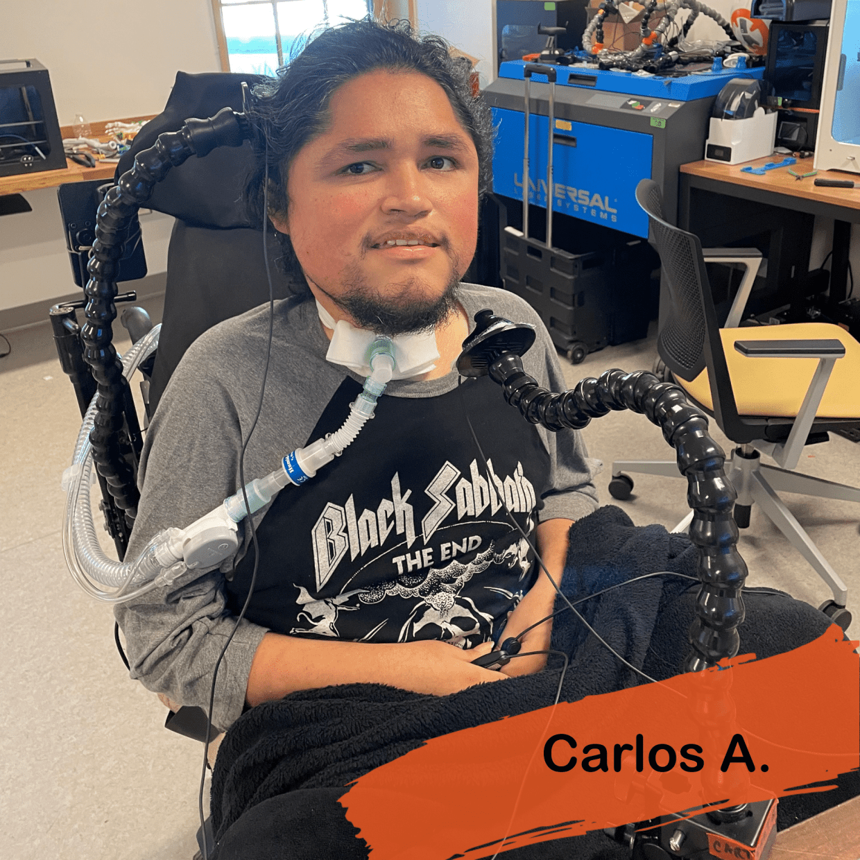 A photo of Carlos getting back to gaming. He has dark hair and a beard he is wearing a Black Sabbath t-shirt