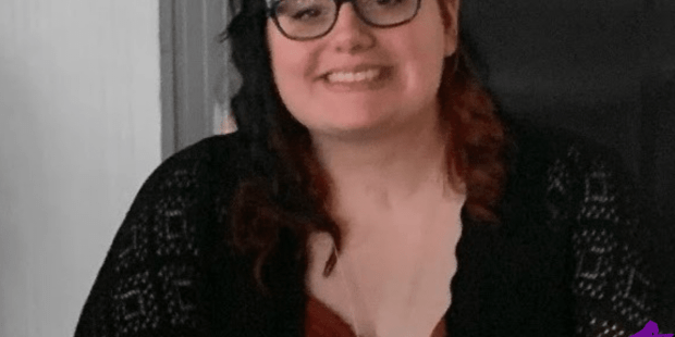 A photo of Courtney. She has long dark hair and she is wearing glasses and smiling.