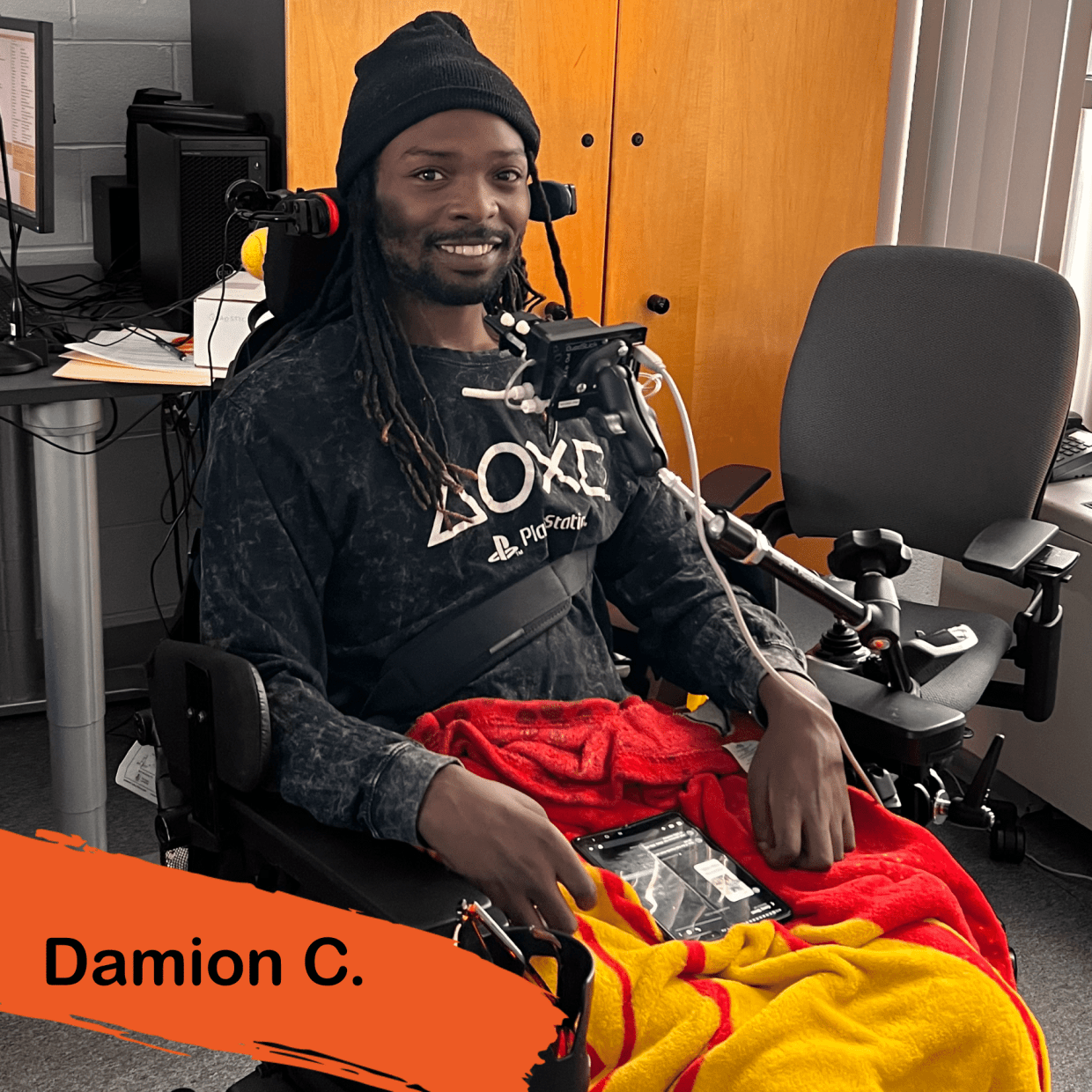 A photo of Damion with his adaptive gaming equipment, the QuadStick ready to game and socialize with friends.