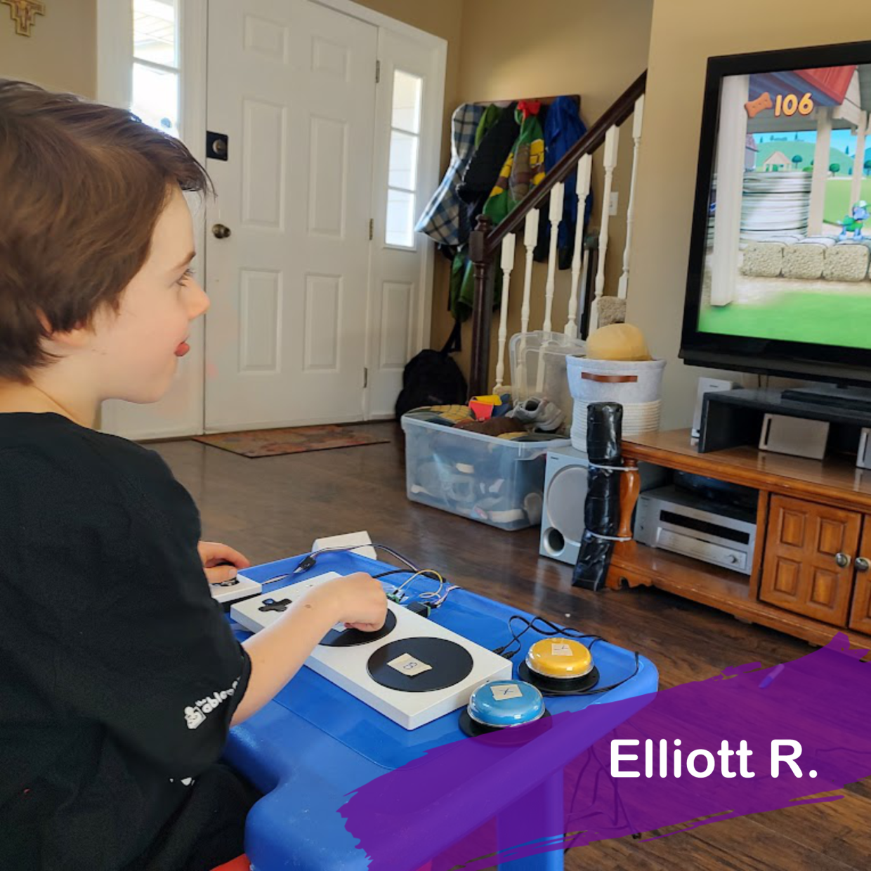 A photo of Elliott playing a video game with his adaptive gaming controller setup