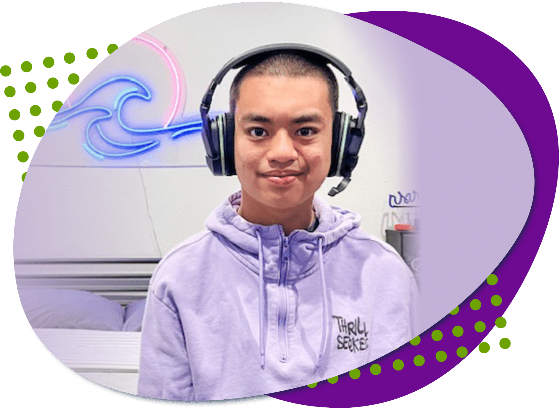 A photo of Isaiah he is wearing a purple hoodie and black headphones after working with AbleGamers to find the right adaptive gaming controller