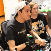 peer counselor helping a young man find the right adaptive controller