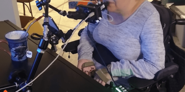 Jessica, a Caucasian female using a quadstick, a controller that you use your mouth with.