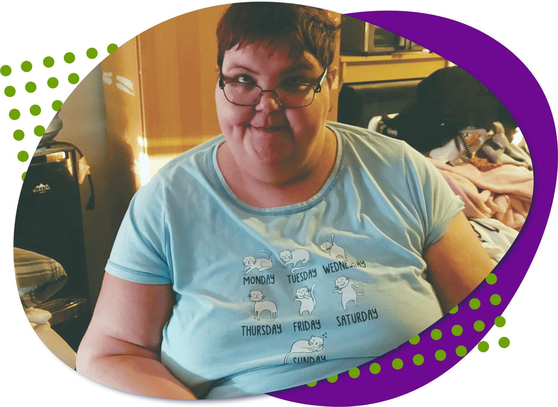 Karina B ina blue shirt, looking at the camera. She has short reddish hair and glasses.