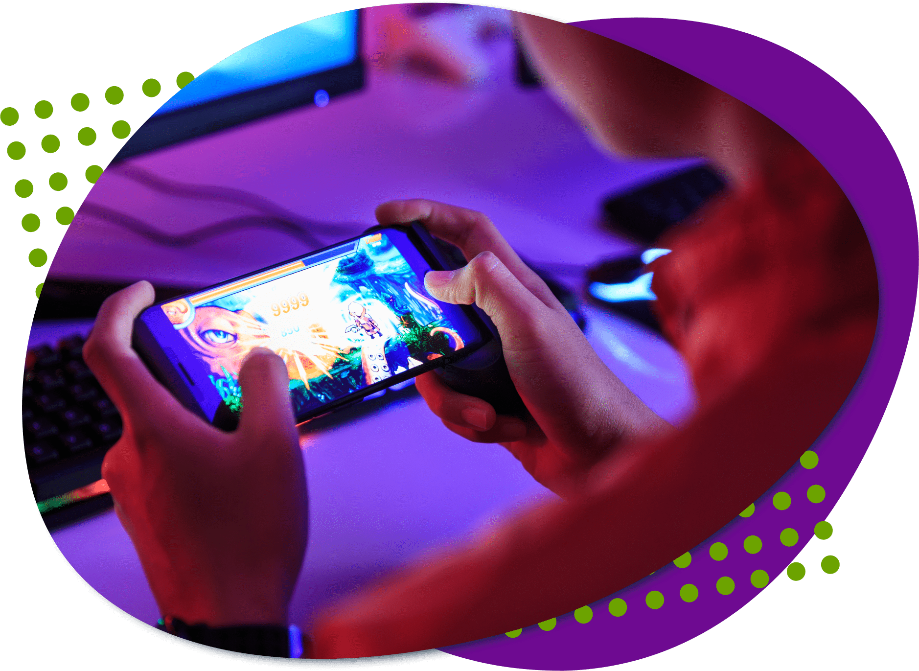 mobile gaming stack An photo taken from behind an individual who is sitting holding a phone playing a video game. A computer screen and keyboard are in front of the individual.