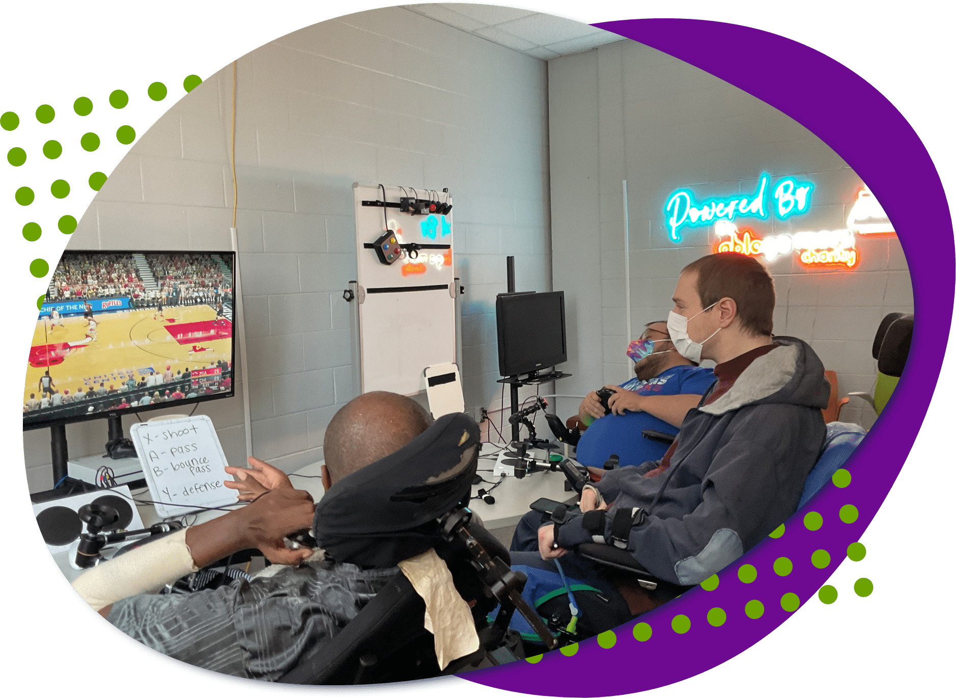 A photo of Peer Counselor Aaron playing a video game with two other individuals at Powered by AbleGamers partner site Ability KC