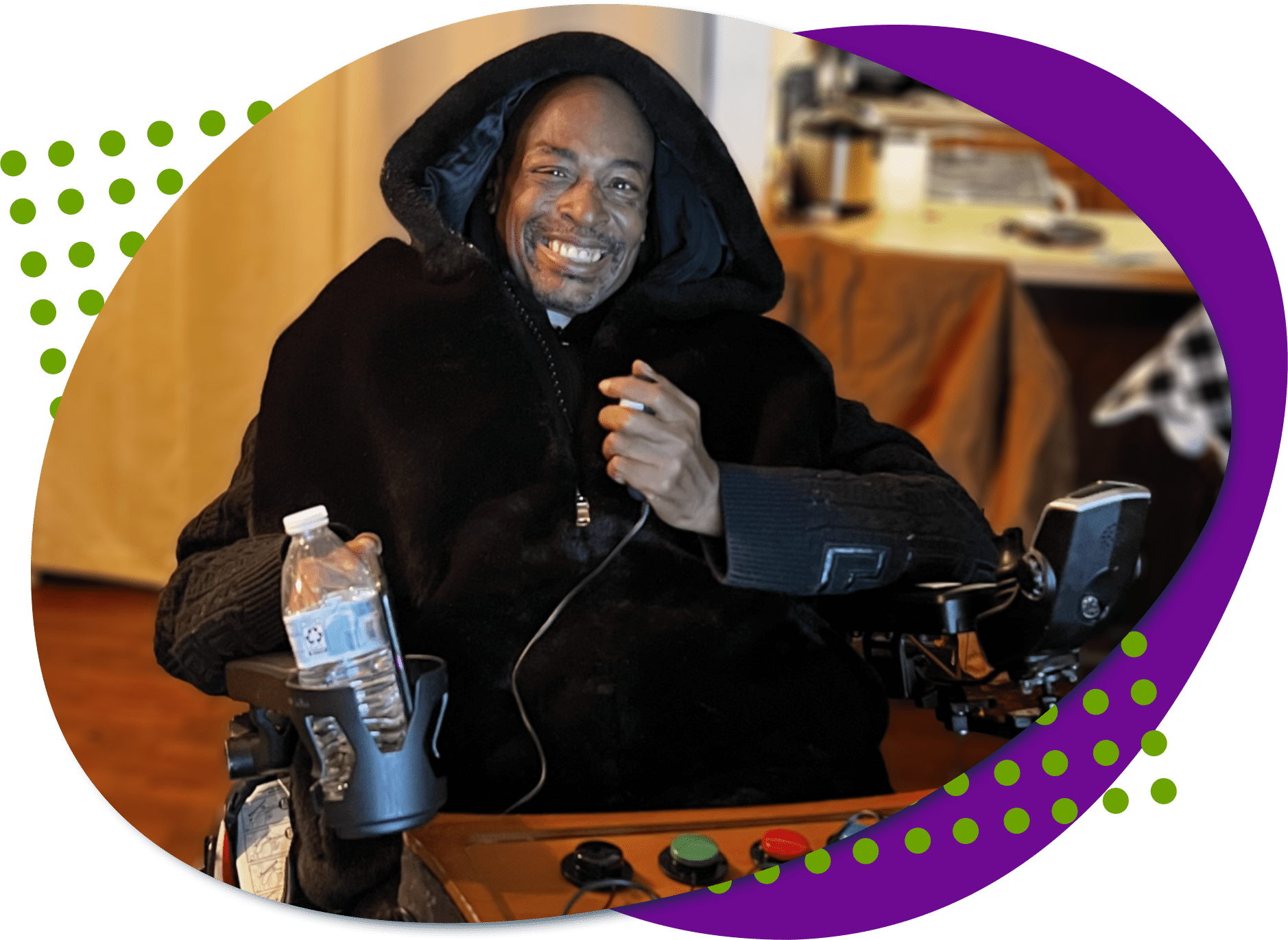 Roland, an African=America male with a black hoodie. He is in a wheelchair holding a joystick in his hand.