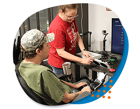 veteran photo stack AbleGamers Peer Counselor Jessie showing a young man how to set up an xBox adaptive controller during a peer counseling session
