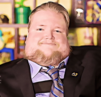 a photo of Steven Spohn wearing a smile and a suit with a gray tie with stripes and an Ablegamers controller pin on his lapel